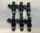 Side view of a set of six 12568557 fuel injectors showing the injector bodies, electrical connectors, O-rings, and nozzles