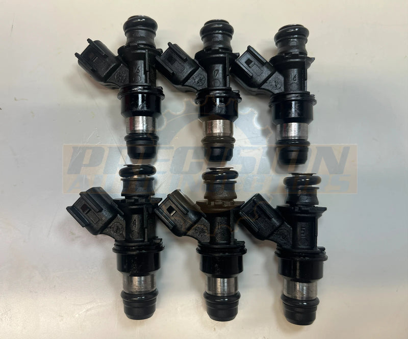 Side view of a set of six 12568557 fuel injectors showing the injector bodies, electrical connectors, O-rings, and nozzles